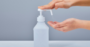 Beyond the Unit Engaging Off-Unit and Across-Unit Staff in Hand Hygiene and Infection Prevention. Image of a hand sanitizer bottle with a person pressing it