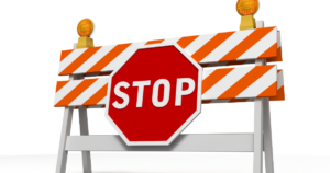 Image of construction barrier in orange with the word "stop" in front of it. Barrier Analysis