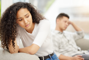 Woman in the leaning away from her partner looking sad and distressed. Forgiveness struggles Forgiveness