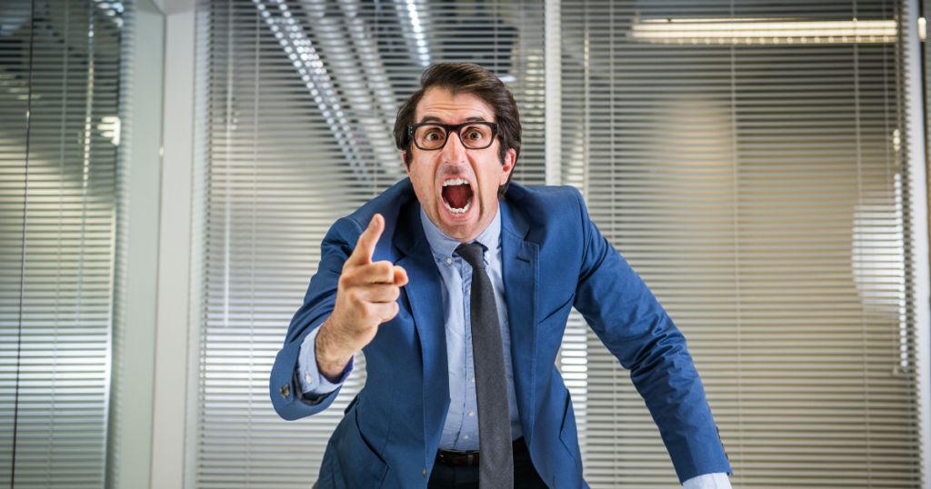 Image of a man in a suit yelling domineeringly. How Overbearing Behavior Develops and Why It Feels So Draining