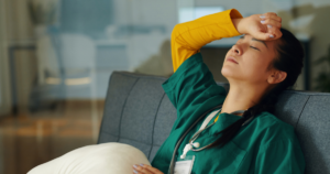 Image of a nurse sitting on a floor with her head leaned back, exhausted. The Hidden Early Warning Signs of CLABSI